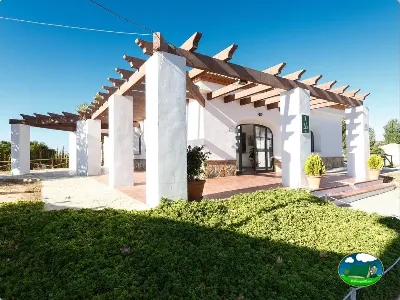 Glamping blanco con pérgola de madera y vistas al entorno del Camping La Sierrecilla, Humilladero (Málaga)