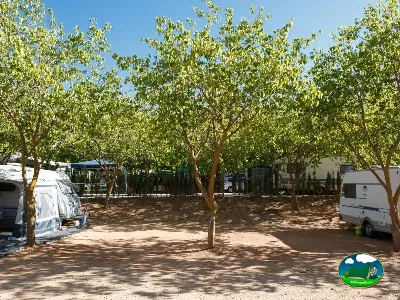 Parcela con sombra de árboles y caravanas del Camping La Sierrecilla, Humilladero (Málaga)
