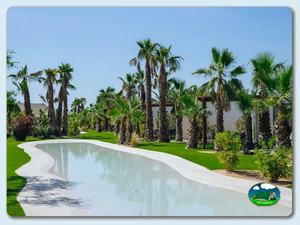 Piscina con vistas a palmeras y bungalows del Camping Alannia Costa Blanca, Crevillente (Alicante)