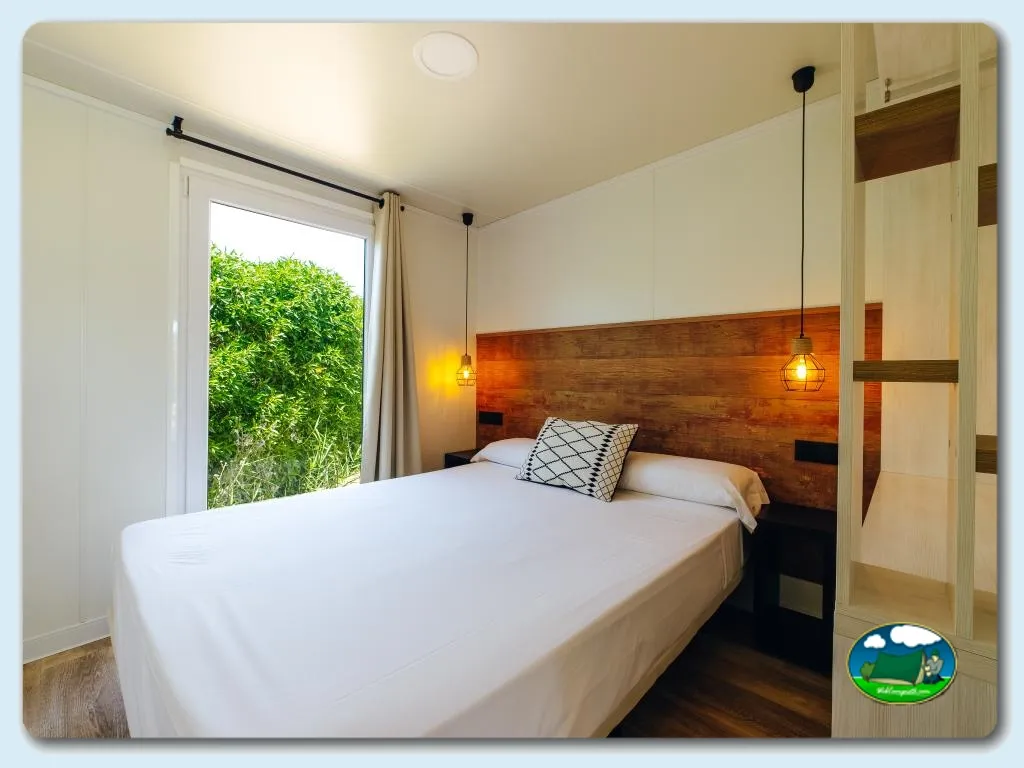 Bungalow interior con cama doble y vistas a la naturaleza del Camping Alannia Costa Blanca, Crevillente (Alicante)