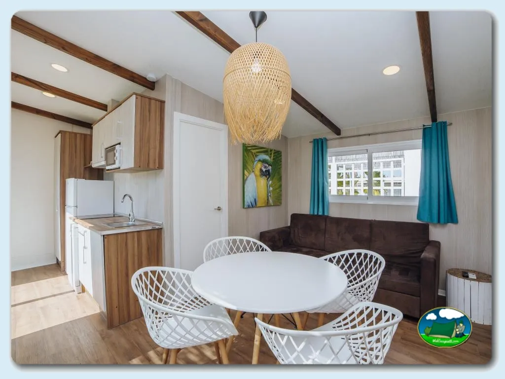 Bungalow interior con cocina, zona de estar y lámpara de diseño del Camping Alannia Costa Blanca, Crevillente (Alicante)