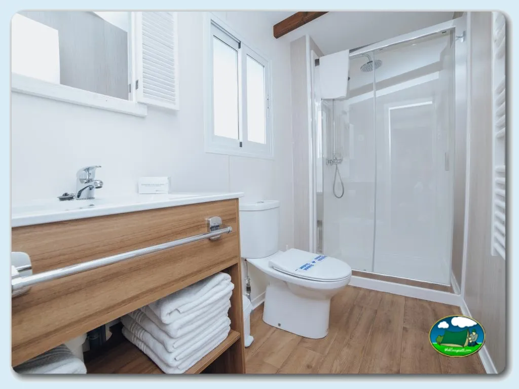 Cuarto de baño con ducha, lavabo y mueble de madera del Camping Alannia Costa Blanca, Crevillente (Alicante)