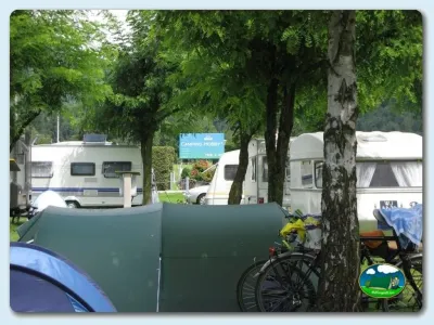 Parcela arbolada con tienda de acampada y mobil-home del Camping Lazy Rancho, Unterseen (Interlaken)