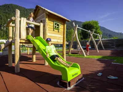 Parque infantil con tobogán y montaña al fondo del Camping Lazy Rancho, Unterseen (Interlaken)