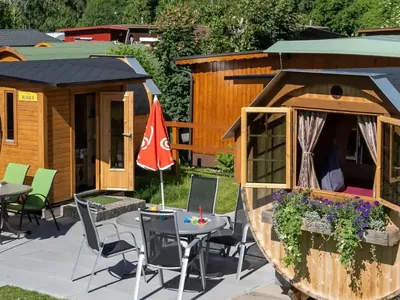 Bungalow de madera con terraza y sombrilla del Camping Lazy Rancho, Unterseen (Interlaken)