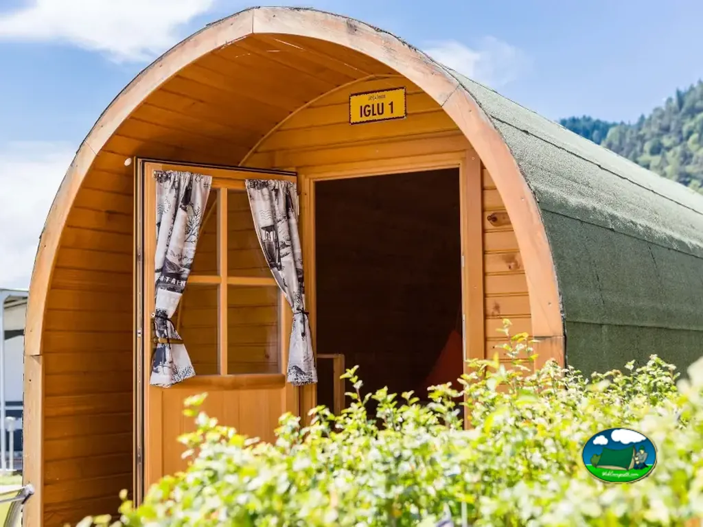 Interior de iglú de madera con cama elevada de Camping Lazy Rancho, Unterseen