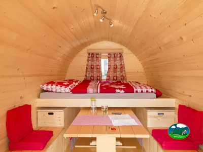 Interior del Love Iglu con cama doble y mesa de Camping Lazy Rancho, Unterseen