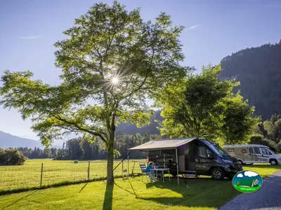 Autocaravana bajo un árbol en el área Family de Camping Lazy Rancho, Unterseen