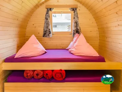 Interior de iglú de madera con cama doble de Camping Lazy Rancho, Unterseen