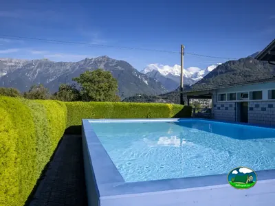 Piscina exterior con vistas a las montañas de Camping Lazy Rancho, Unterseen