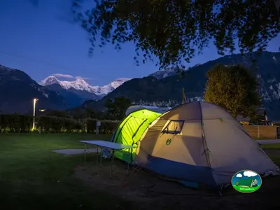 Tienda iluminada al atardecer en Camping Lazy Rancho, Unterseen