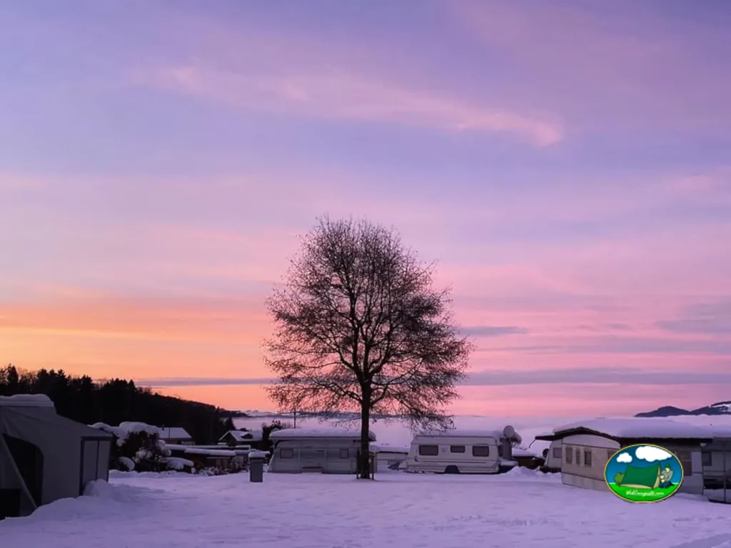 Parcelas nevadas de Camping Stuhlegg al atardecer, Krattigen