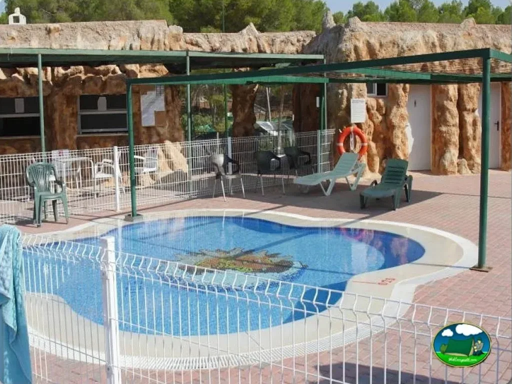 Piscina con zona de descanso y alojamientos rupestres del Camping Los Viveros, Calasparra (Murcia)