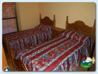 Habitación con dos camas de madera del Camping La Dehesa, Agallas (Salamanca)