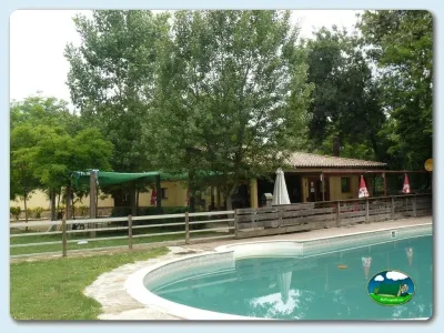 Piscina con vistas al entorno arbolado, edificio de servicios del Camping Besalú, Besalú (Girona)