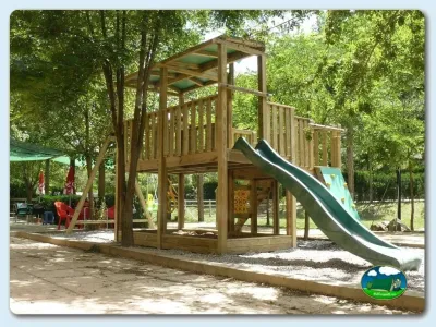 Parque infantil con tobogán y estructura de madera del Camping Besalú, Besalú (Girona)