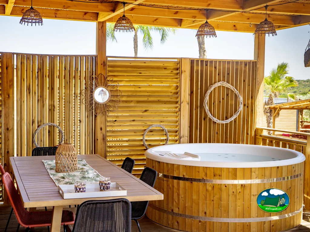 Glamping con jacuzzi exterior y zona de comedor del Camping L´Orangeraie, Cálig (Castellón)
