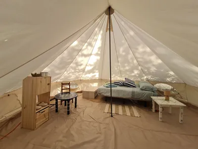 Glamping tipi interior con cama y mobiliario de madera del Camping Piedade, Elvas (Portalegre)