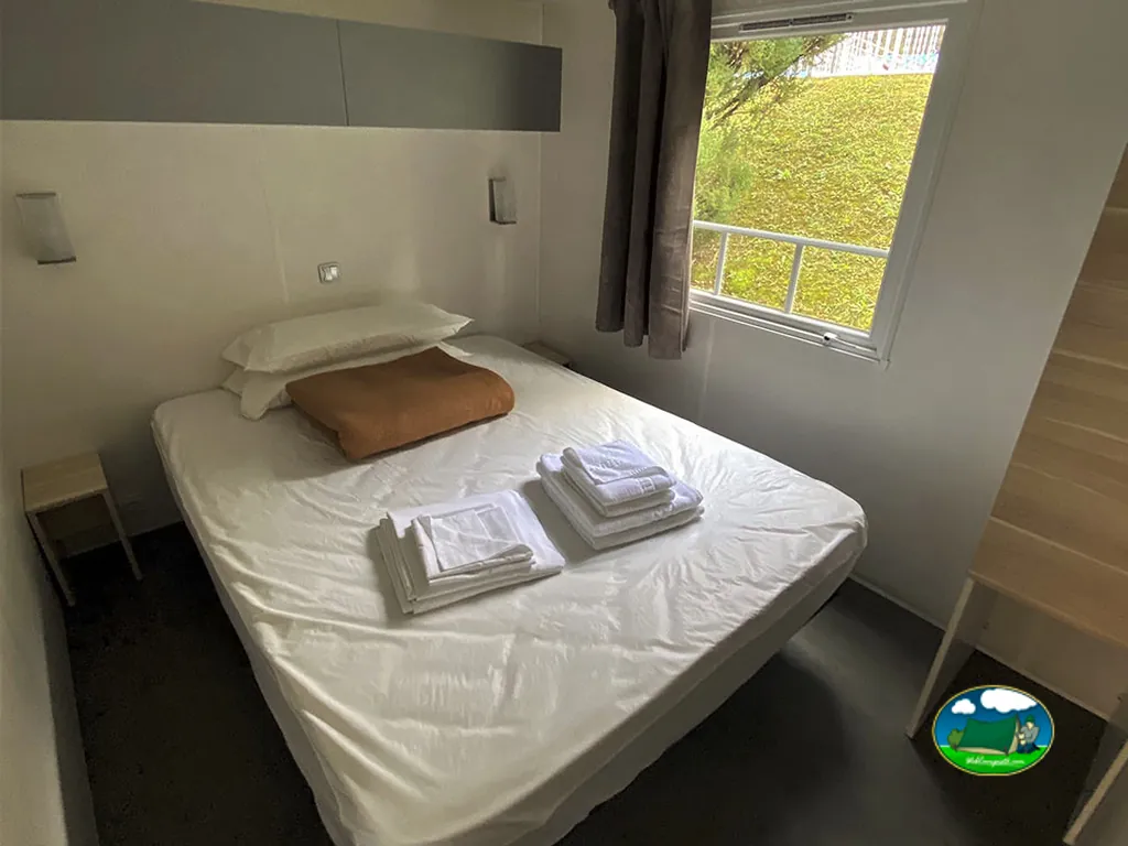 Mobil-home interior con cama doble y vistas al jardín del Camping Igara de San Sebastián, San Sebastián (Gipuzkoa)