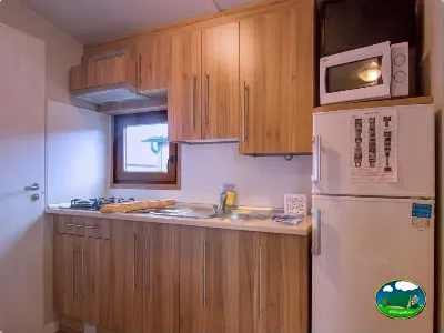 Cocina de mobil-home con muebles de madera y electrodomésticos del Camping Zumaia, Zumaia (Gipuzkoa)