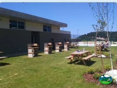 Zona de ocio con mesas de picnic y piscina, vistas a la montaña del Camping Zumaia, Zumaia (Gipuzkoa)