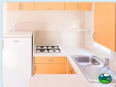 Cocina mobil-home con muebles naranja del Camping Valencia El Saler, El Saler (Valencia)