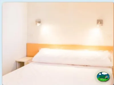 Habitación doble con cabecero naranja del Camping Valencia El Saler, El Saler (Valencia)