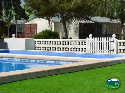 Piscina con bungalows y zona de césped del Camping Valencia El Saler, El Saler (Valencia)