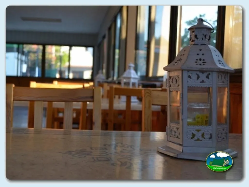 Restaurante interior con mesas de madera del Camping Valencia El Saler, El Saler (Valencia)
