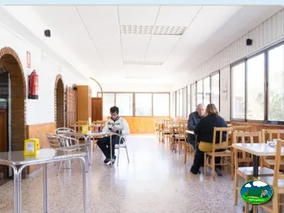Restaurante interior con mesas y sillas de madera del Camping Valencia El Saler, El Saler (Valencia)