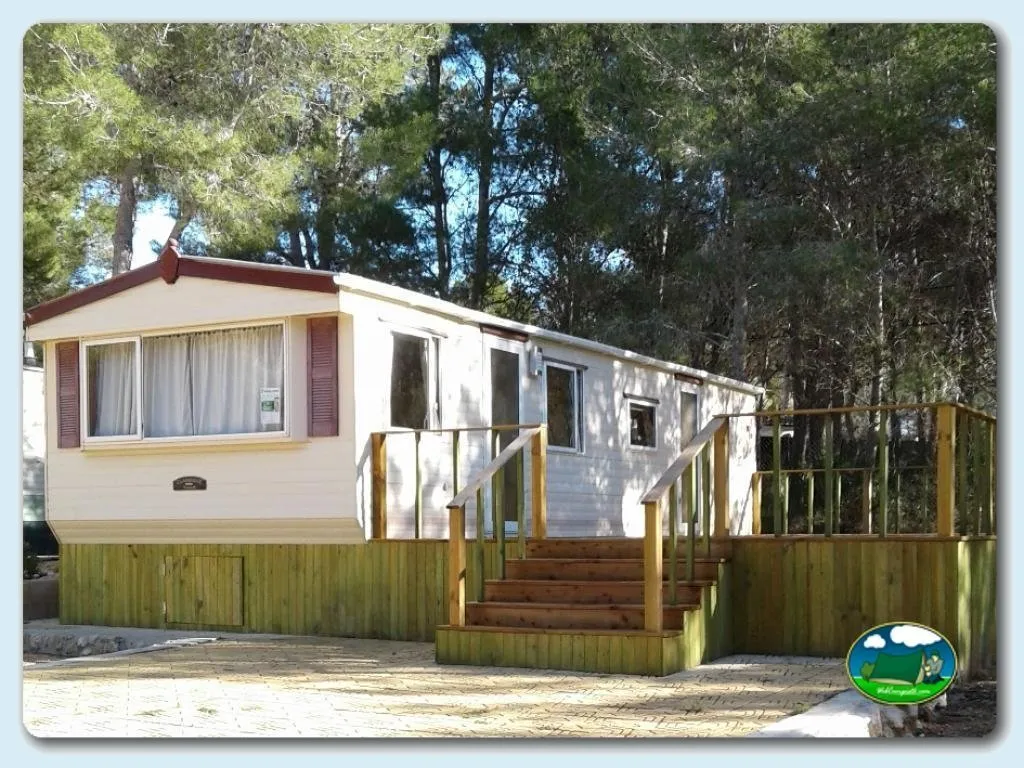 Mobil-home con terraza de madera entre árboles del Camping Puig Campana, Alicante (Alicante)