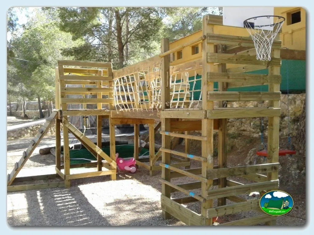 Parque infantil con estructura de madera y canasta de baloncesto del Camping Puig Campana, Alicante (Alicante)