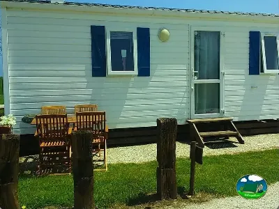 Mobil-home con terraza y sillas de madera del Camping Rinlo, Rinlo (Lugo)