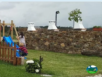 Parque infantil con tobogán azul y vistas a parcelas del Camping Rinlo, Rinlo (Lugo)