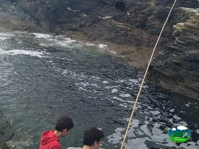Playa junto al mar con acantilados rocosos del Camping Rinlo, Rinlo (Lugo)