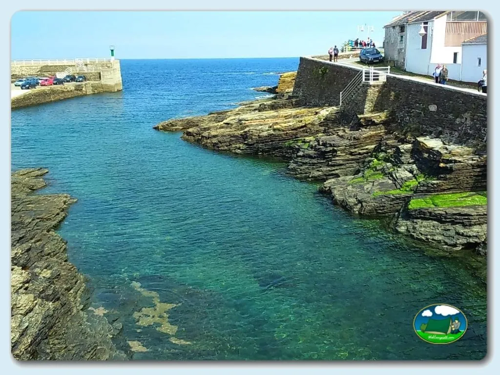 Junto al mar, cala rocosa con agua turquesa y acceso directo del Camping Rinlo, Rinlo (Lugo)