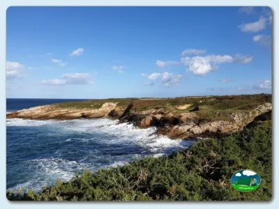 Playa junto al mar con acantilados y vegetación del Camping Rinlo, Rinlo (Lugo)