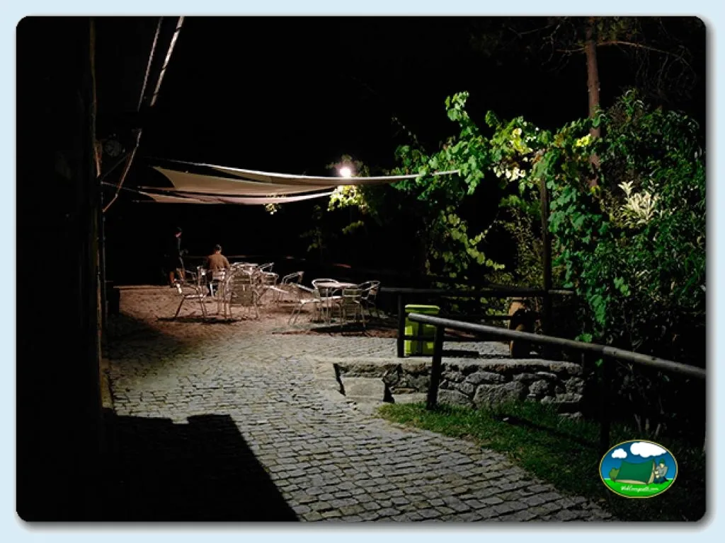 Área de descanso nocturna con asientos y sombrilla del Camping Gêres Green Park, Cabril (Viana Do Castelo)