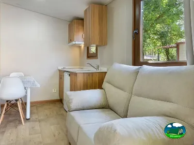 Glamping interior con salón, cocina equipada y vistas al bosque del Camping Borda Bisaltico, Hecho (Huesca)
