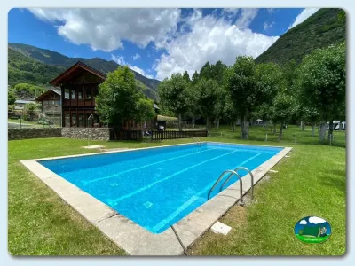 Piscina con vistas a la montaña y bungalow del Camping Pica d'Estats, Areu (Lleida)