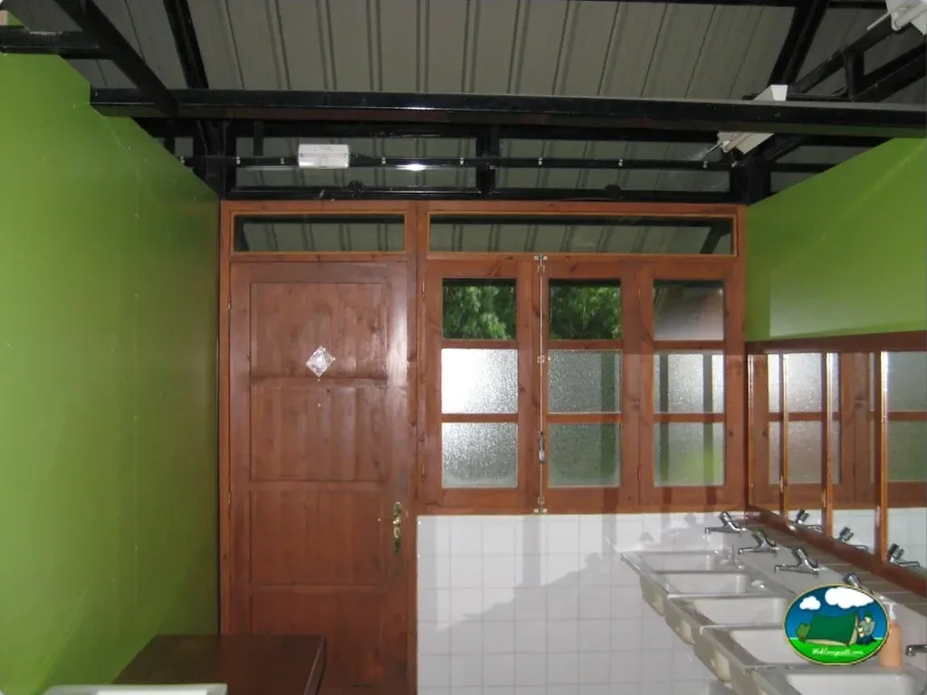 Aseos con lavabos y puerta de acceso del Camping Pica d'Estats, Areu (Lleida)