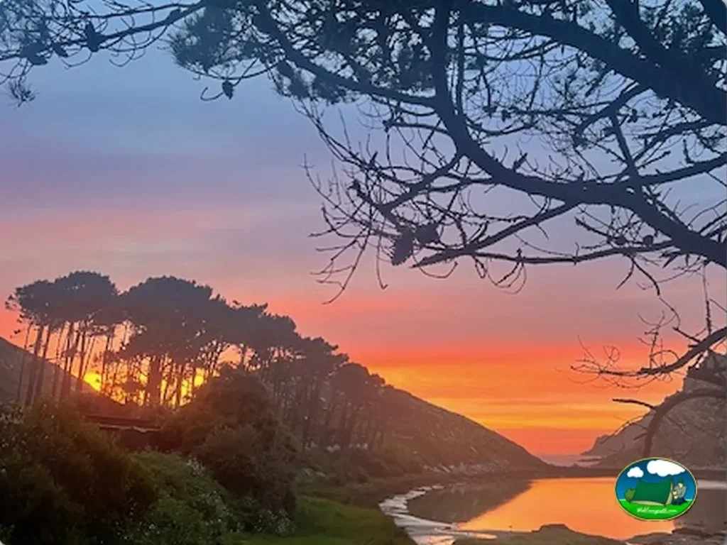 Río al atardecer con montaña boscosa del Camping Islas Cíes, Vigo (Pontevedra)