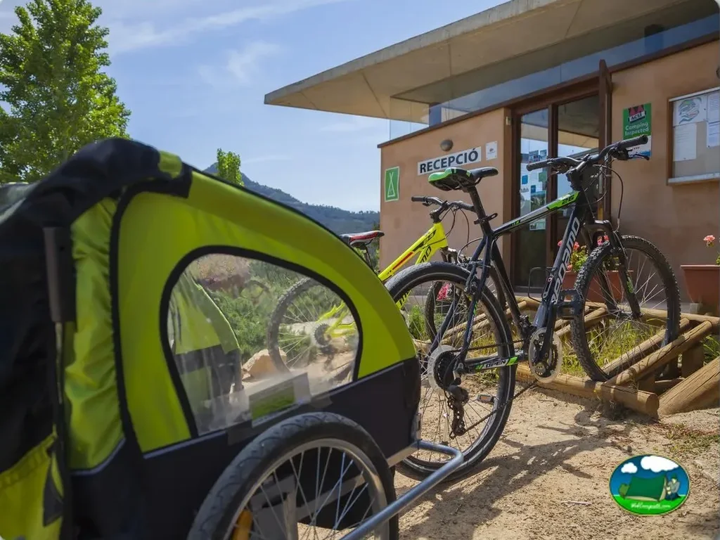Remolque bicicleta y bicicletas junto a recepción con montaña del Camping Terra Alta, Bot (Tarragona)