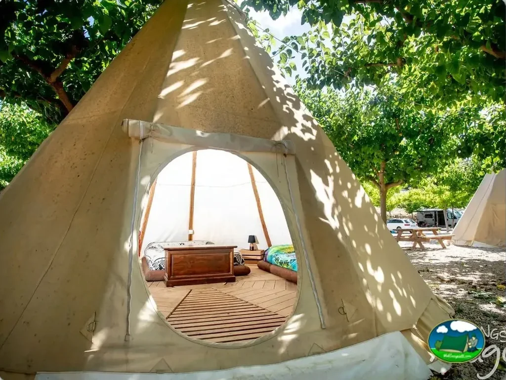 Glamping tipi con interior amueblado bajo árboles del Camping El Roble, Valderrobres (Teruel)