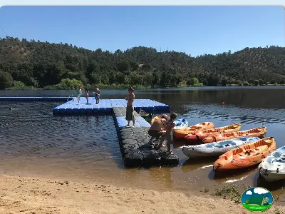 Playa junto al lago con kayaks y pontón flotante del Camping Municipal de Ortiga, Ortiga (Santarém)