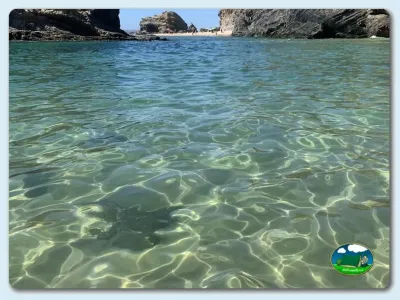 Playa junto al mar con agua cristalina y acantilados del Camping Costa do Vizir Beach Village, Porto Covo (Setúbal)