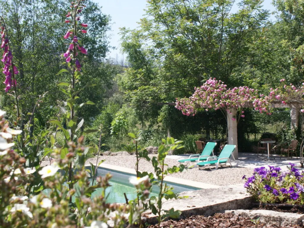 Parcela con jardín florecido y hamacas del Camping Quinta do Retiro, Tábua (Coimbra)