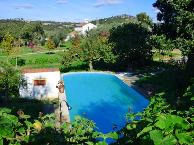 Piscina con vistas a la montaña, rodeada de vegetación del Camping Lapa dos Gaivões, Arronches (Portalegre)