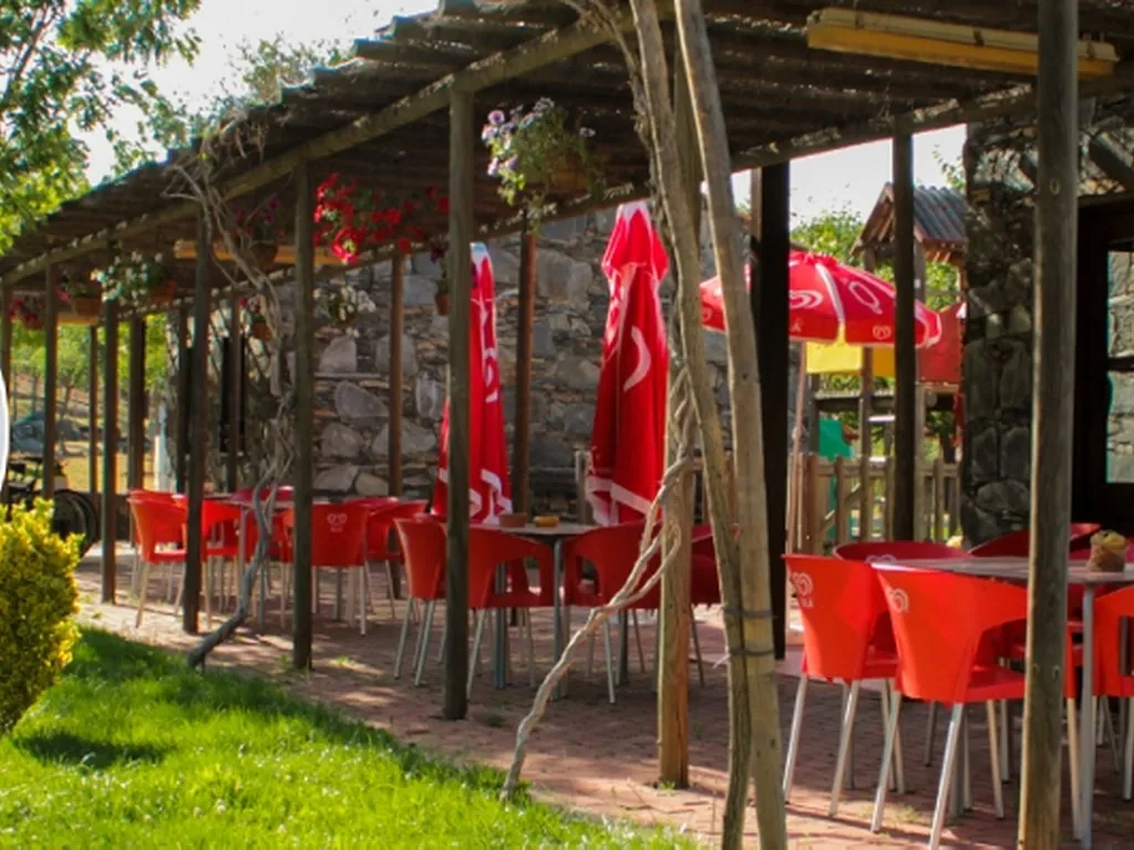 Restaurante con terraza sombreada y sillas rojas del Camping Oleiros, Oleiros (Castelo Branco)
