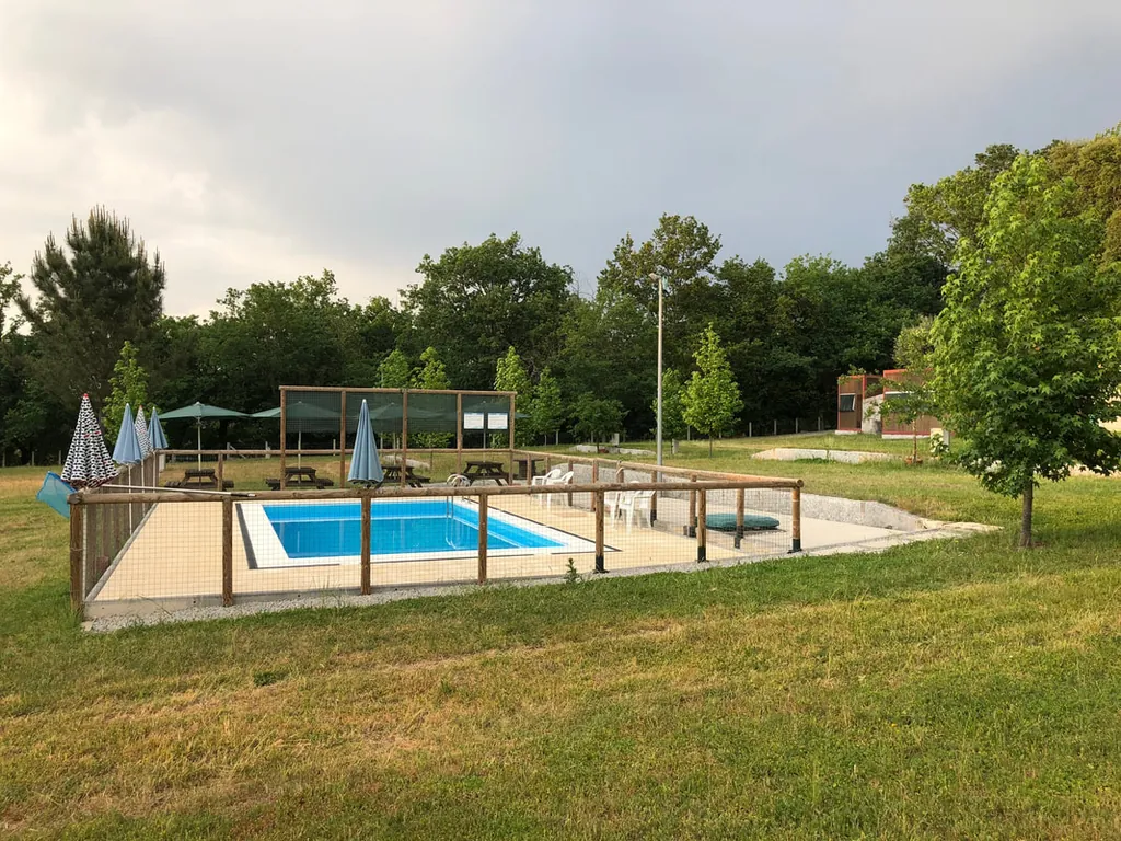 Piscina con valla de seguridad y zona de descanso del Camping Garfepark, Póvoa de Lanhoso (Braga)